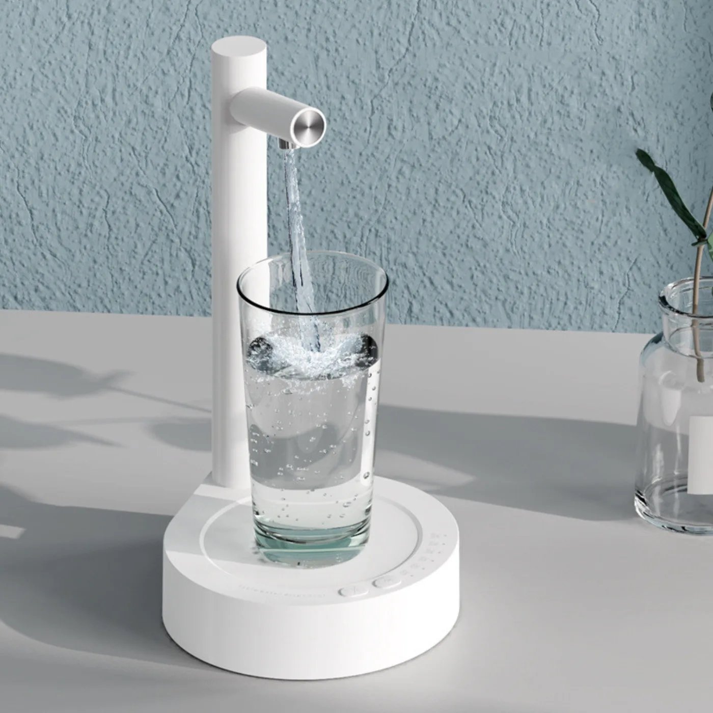 White pump pouring water into a glass on a shelf